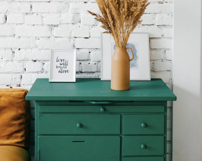 Green wooden drawers with decorative items on top